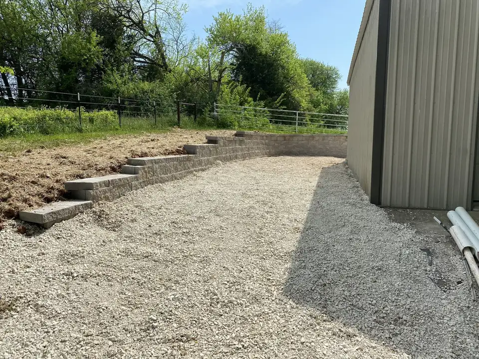 Block steps along a gravel pad beside a shop building