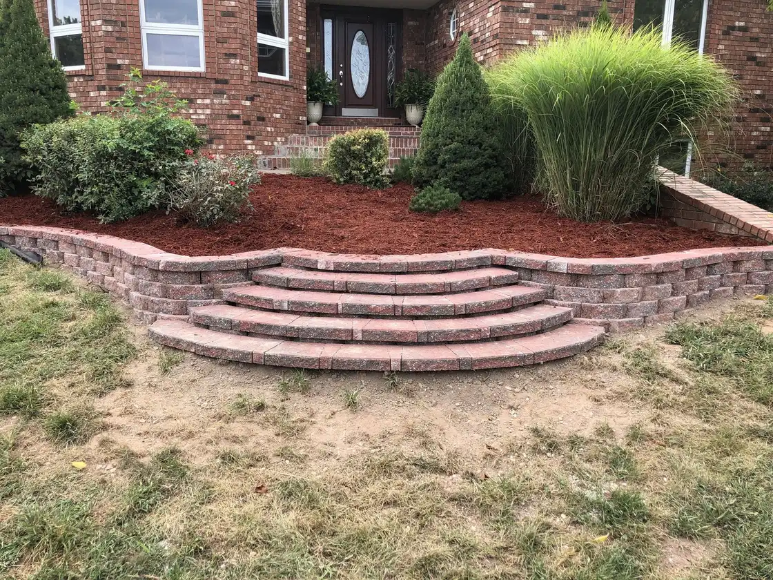 Curved brick retaining wall with steps up to the front walk, one of our jobs