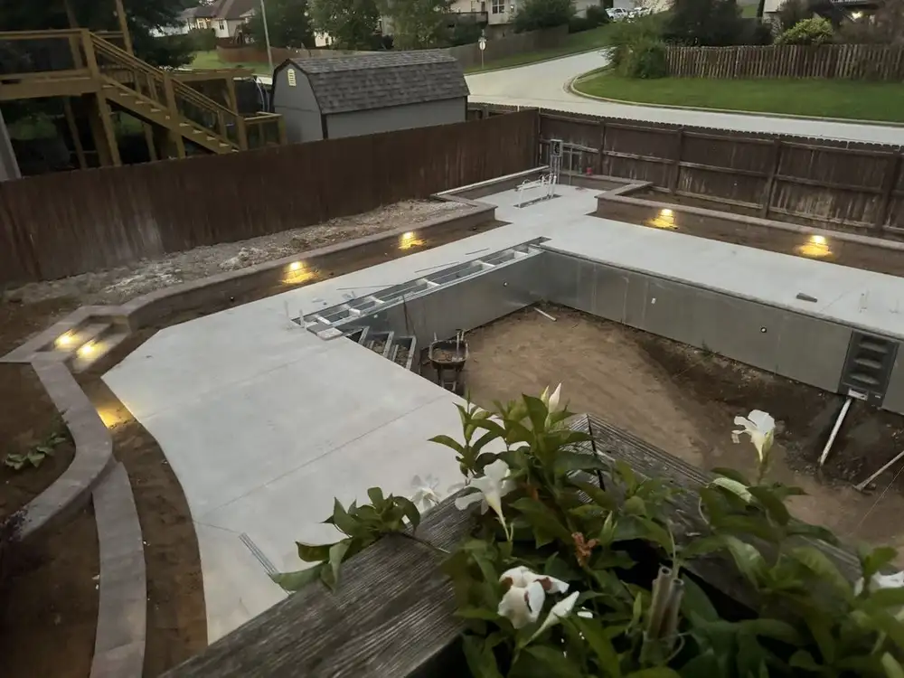 Pool going in, with the deck poured and lights in the block walls, one of our jobs