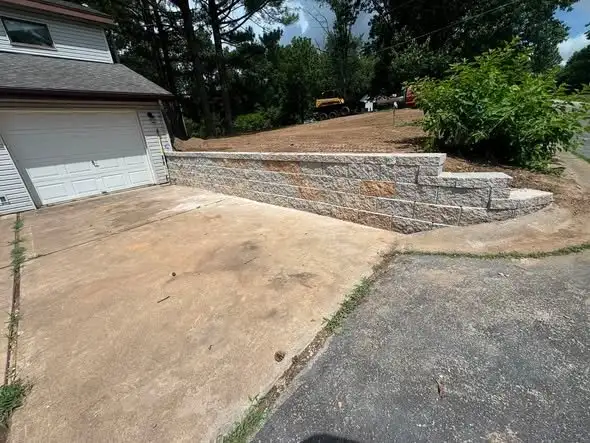 Segmental block retaining wall along a driveway with steps built into the corner