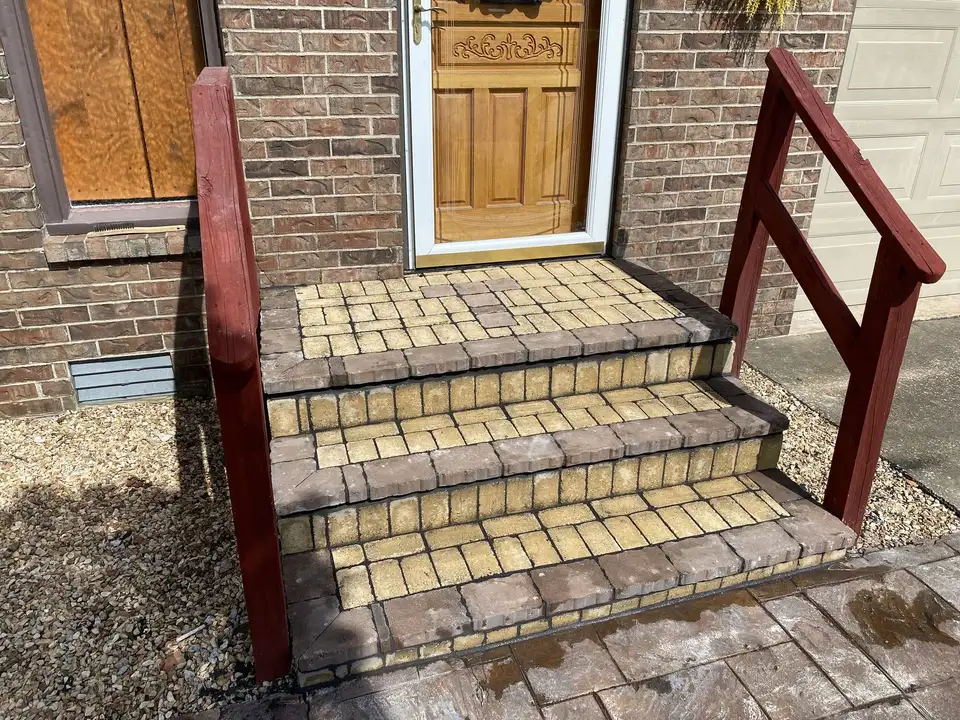 Paver steps with a railing at a front door