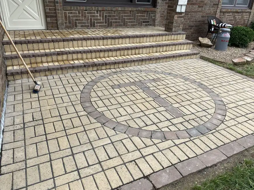 A paver patio with a circle inlay at a back door